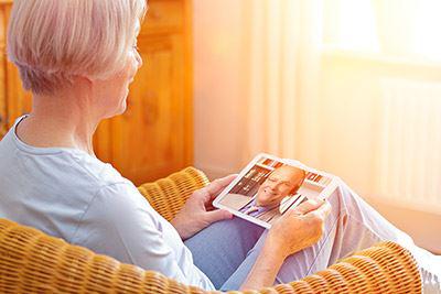 Eine ältere Dame schaut etwas auf ihrem Tablet