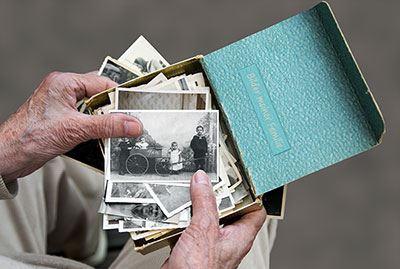 Eine geöffnete Fotokiste mit vielen alten Fotos