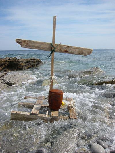 Eine Urne auf einer Holzpalette mit einem Kreuz